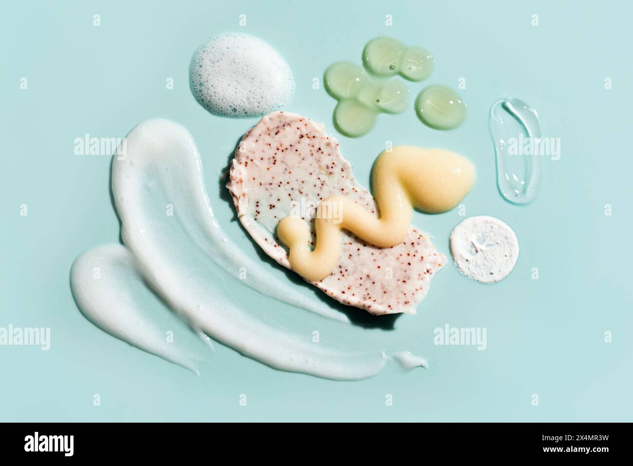 Les produits de beauté cosmétiques frottent la texture de la crème sur fond bleu. Ensemble de divers tampons de soins de la peau, mousse, baume, gel et coups de crème. Banque D'Images