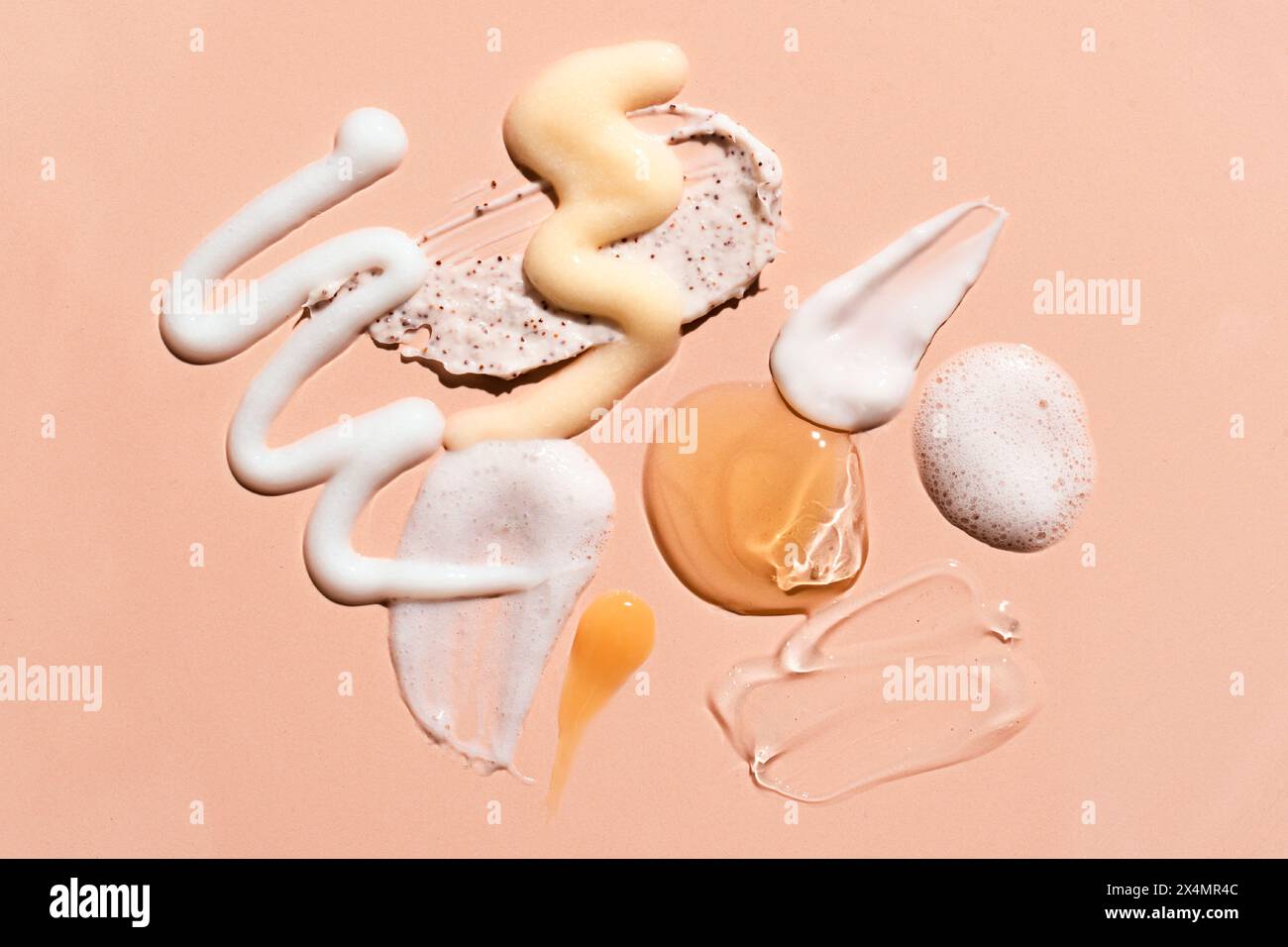 Ensemble de cosmétique échantillon sur fond rose beige. Produits de beauté pour les soins du visage et du corps : hydratant, essence de sérum, mousse nettoyante, tonique, reti Banque D'Images