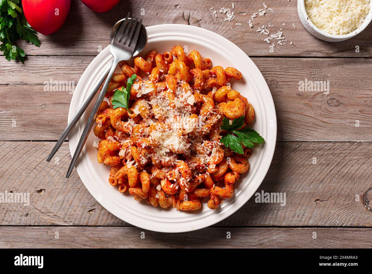 Pâtes Cavatappi avec sauce tomate et parmesan râpé sur table en bois, vue de dessus. Pâtes végétariennes maison avec sauce rouge riche. Banque D'Images