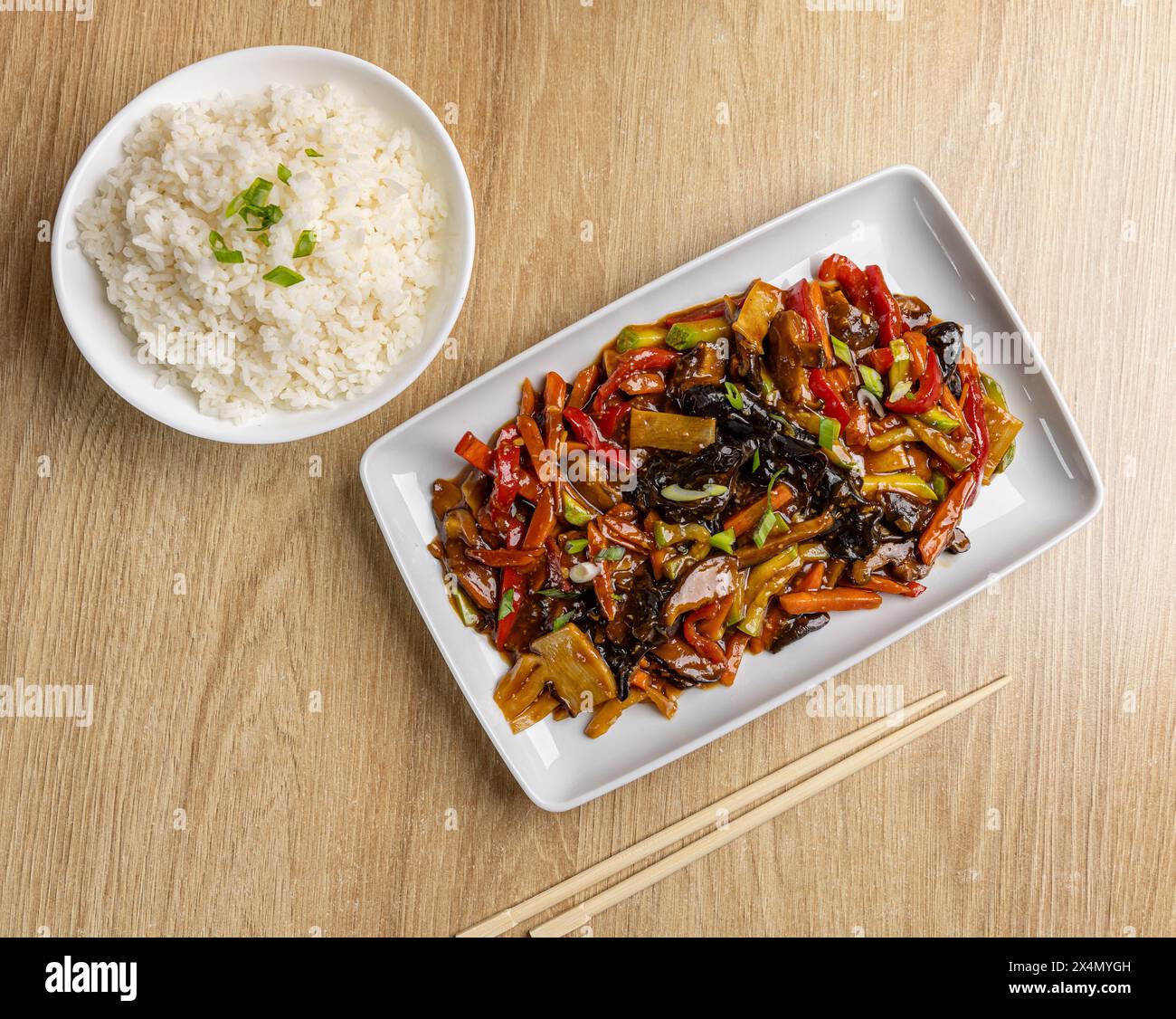 Savoureux plat asiatique aux légumes colorés servi avec du riz blanc Banque D'Images