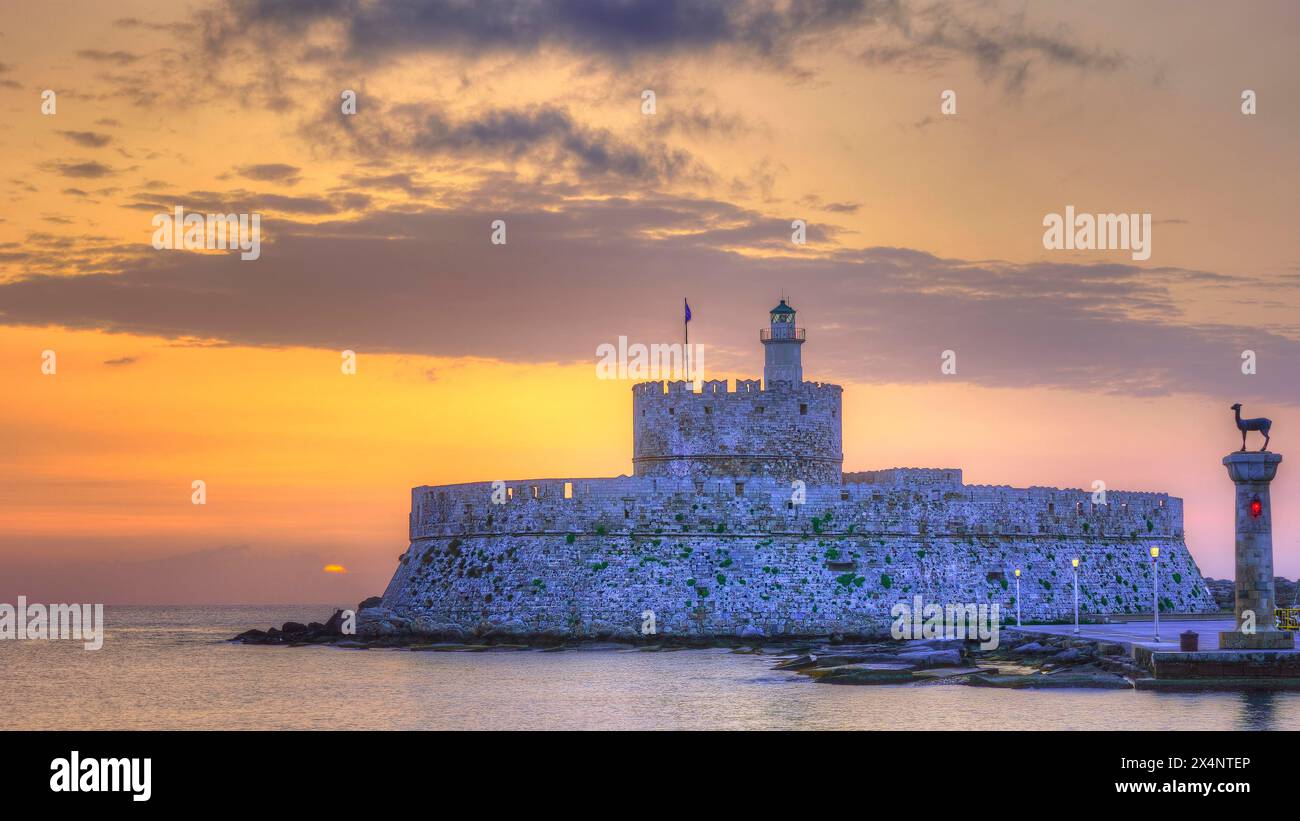 La forteresse près de la côte sous un ciel avec des couleurs de coucher de soleil, lever du soleil, aube, phare, statue de chevreuil européen, Fort de Saint Nikolaos, bal du port Banque D'Images