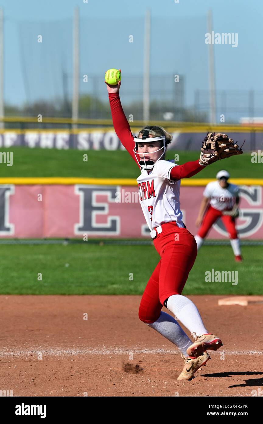 États-Unis : lanceur livrant un terrain à un frappeur en attente pendant un match de softball au lycée. Banque D'Images