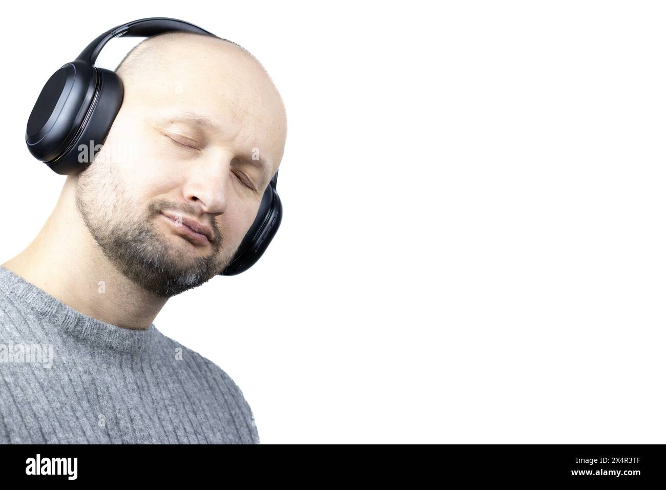 C'est un portrait captivant d'un homme, placé sur un fond blanc dur. Il est vêtu d'un pull en laine grise finement tricoté, les yeux fermés Banque D'Images