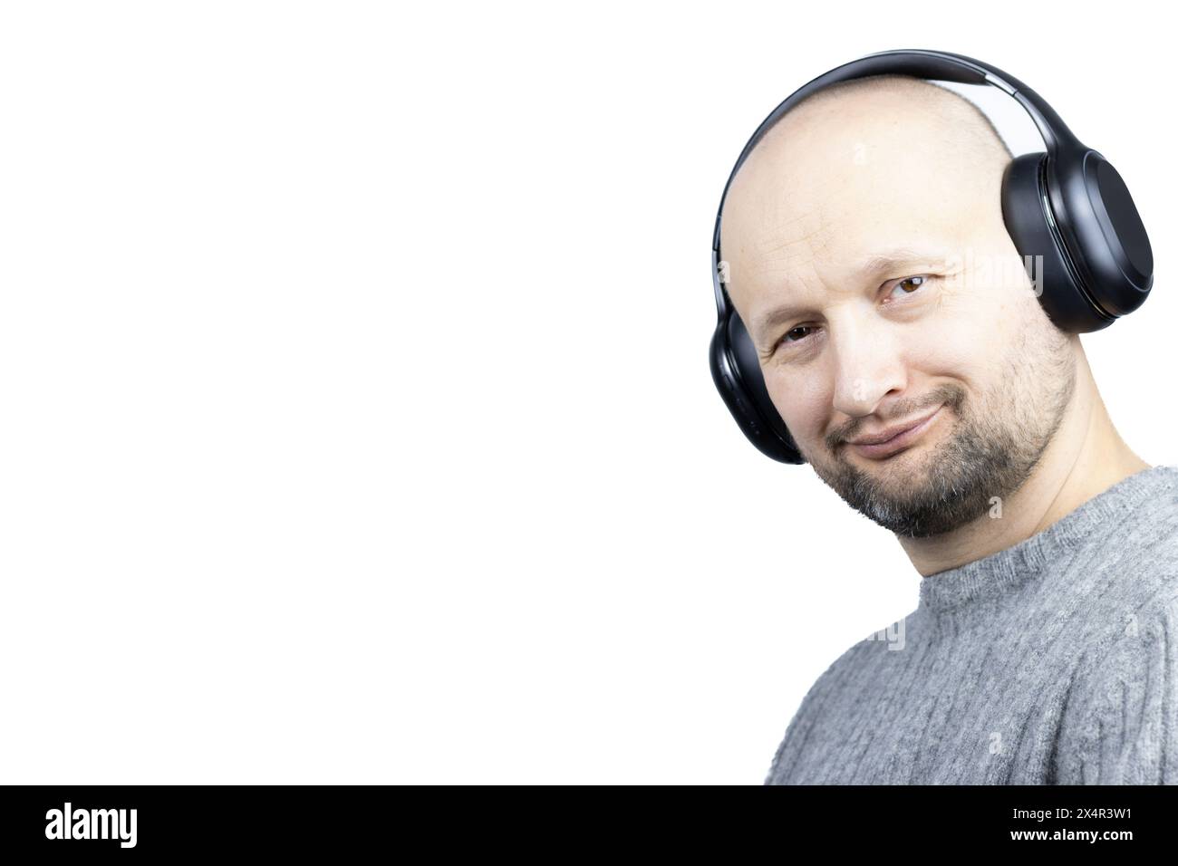 C'est un portrait captivant d'un homme, placé sur un fond blanc dur. Il est vêtu d'un pull en laine grise finement tricoté, son visage exprimant de la joie Banque D'Images
