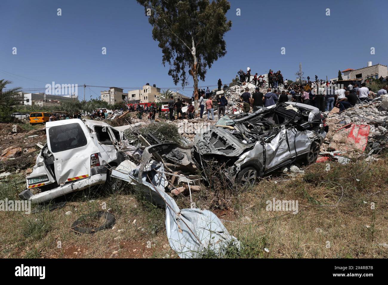 (240505) -- TULKAREM, 5 mai 2024 (Xinhua) -- des Palestiniens traversent les décombres après une opération militaire menée par les forces israéliennes à Deir Al-Ghusoun, une ville de Tulkarem, dans le nord de la Cisjordanie, le 4 mai 2024. Au moins six Palestiniens ont été tués samedi dans une opération militaire menée par les forces israéliennes à Deir Al-Ghusoun, une ville de Tulkarem, dans le nord de la Cisjordanie, selon des sources médicales et sécuritaires palestiniennes. Des sources de sécurité en Palestine ont déclaré que les troupes israéliennes avaient encerclé une résidence dans la ville pendant plus de 15 heures, au cours desquelles plusieurs obus ont été lâchés Banque D'Images