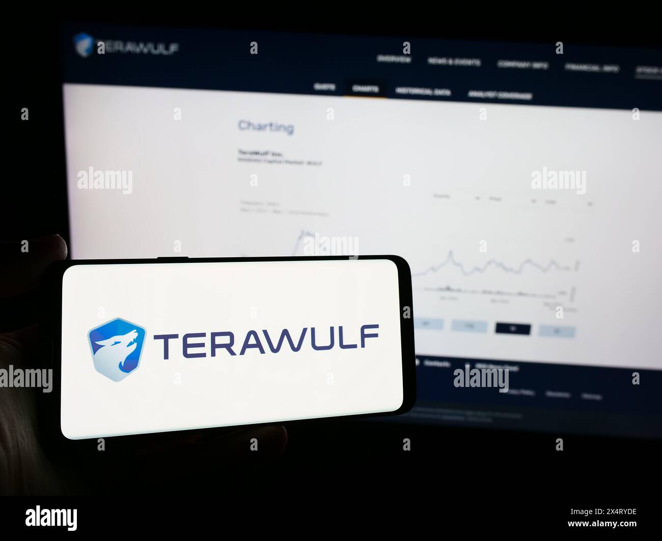 Personne tenant un téléphone portable avec le logo de la société minière américaine de Bitcoin TeraWulf Inc en face de la page Web de l'entreprise. Concentrez-vous sur l'affichage du téléphone. Banque D'Images