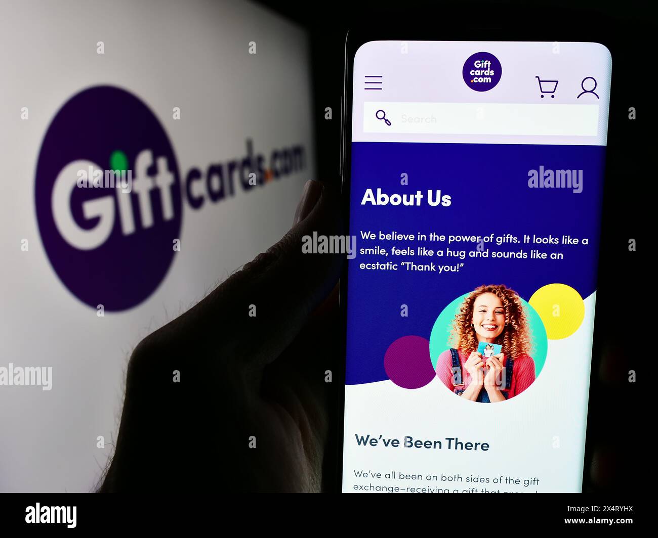 Personne tenant un smartphone avec la page Web de la société de vente au détail de carte-cadeau américaine Giftcards.com LLC devant le logo. Concentrez-vous sur le centre de l'écran du téléphone. Banque D'Images