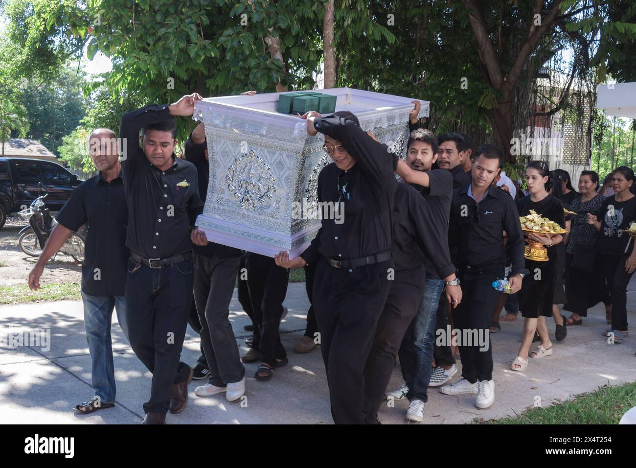 Phatthalung, Thaïlande- 05 avril 2024 : L'homme en noir aide à transporter le cercueil du défunt dans le crématorium pour la crémation Banque D'Images