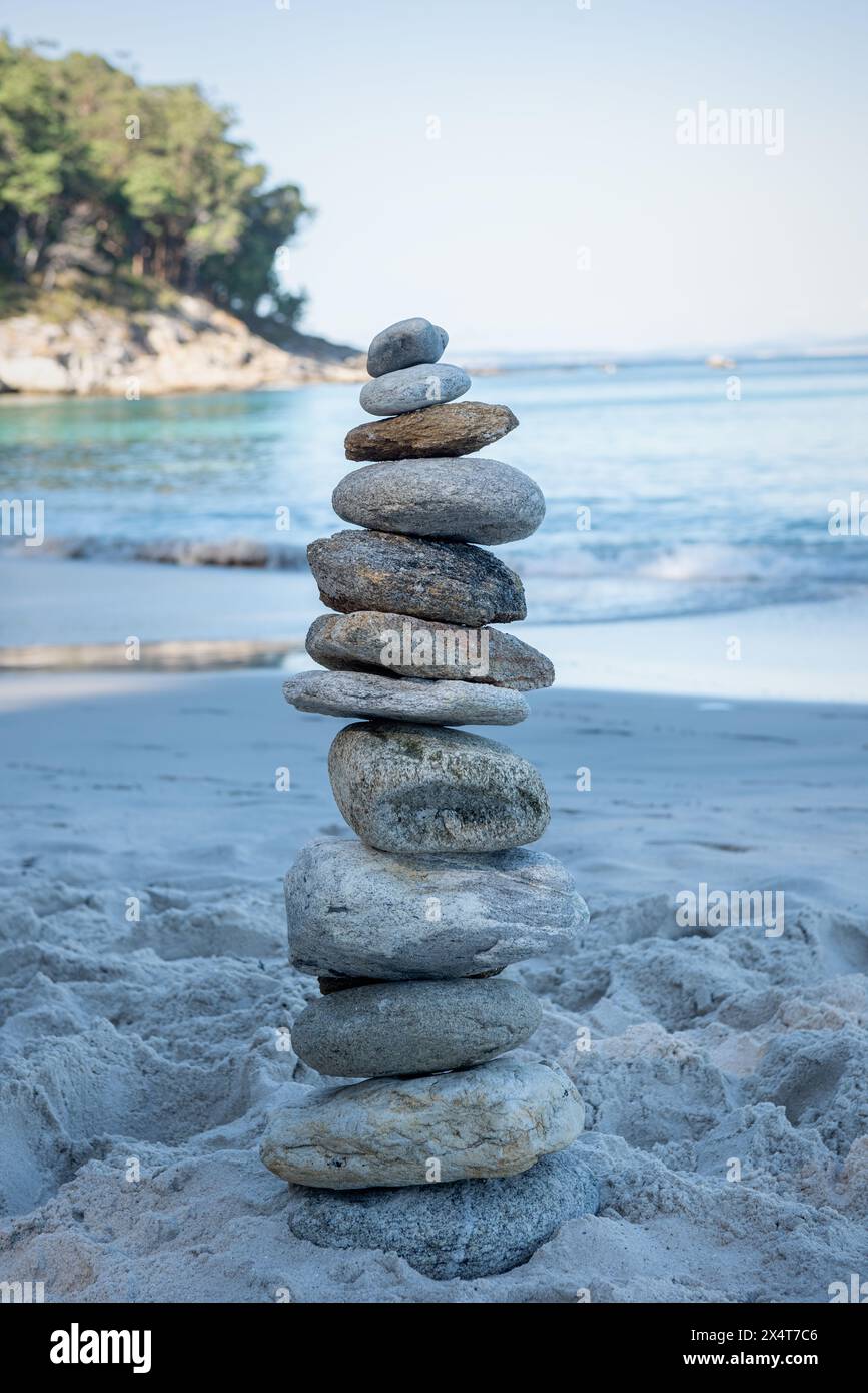 Empiler des pierres sur la côte de la mer dans la nature. Cairn sur la plage de l'océan, tour de cinq galets. Concept d'équilibre et d'harmonie. Calme et esprit Banque D'Images