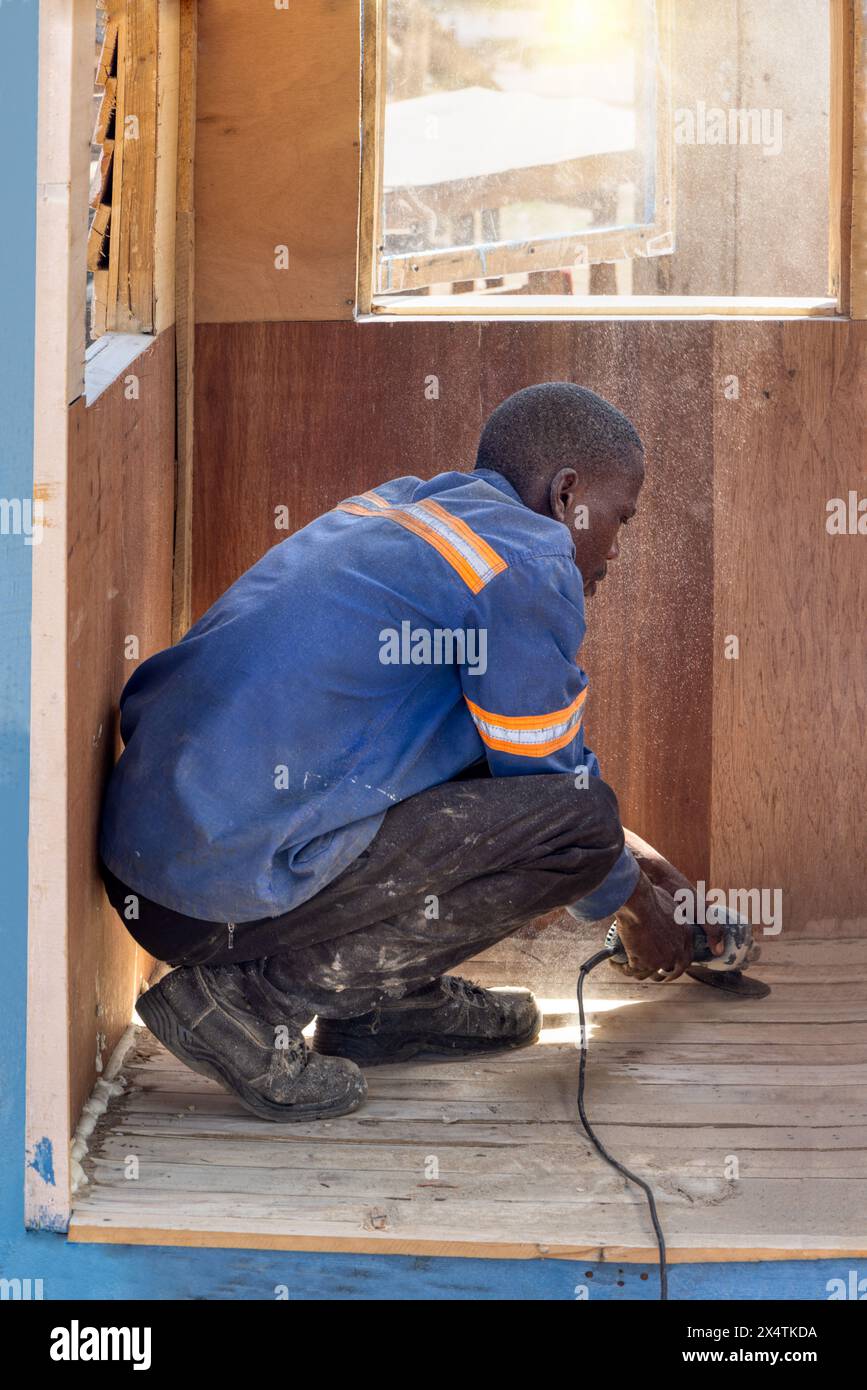 travailleur africain employé de construction de cabine en bois maison de cubby sur le côté de la route, entrepreneur de petite entreprise Banque D'Images