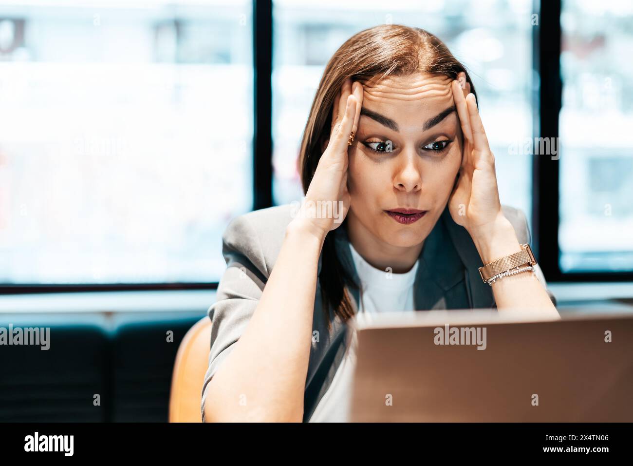 femme d'affaires fatiguée assise devant un ordinateur portable dans un bureau Banque D'Images