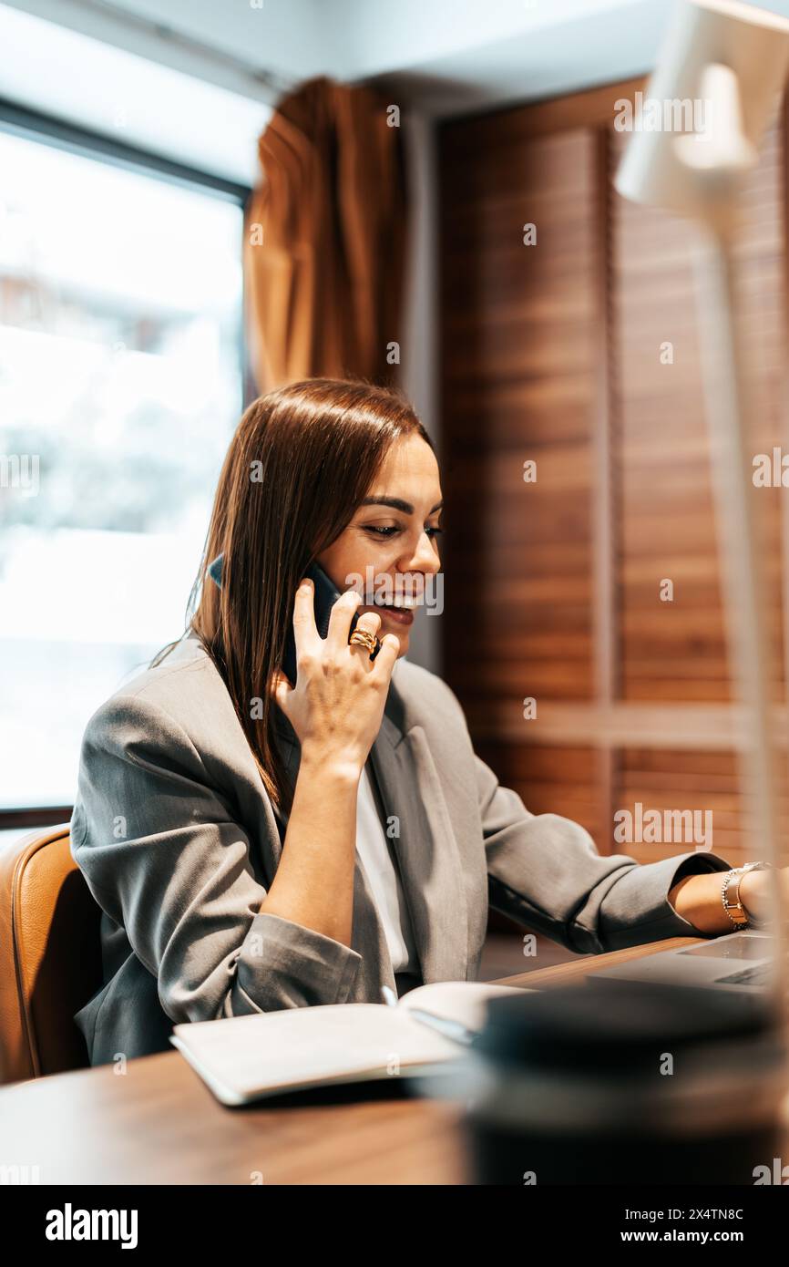 femme travaillant dans un bureau parlant au téléphone Banque D'Images