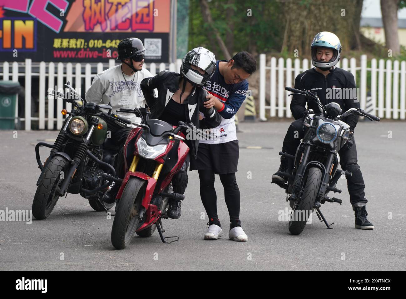 (240505) -- PÉKIN, 5 mai 2024 (Xinhua) -- Un autocar corrige le mouvement de virage d'un motocycliste dans un cinéma drive-in dans le district de Chaoyang, Pékin, capitale de la Chine, le 4 mai 2024. Dans un cinéma drive-in dans le district de Chaoyang, Pékin, quand il n'y a pas de films en cours de journée, des dizaines de motos rugissent sur la place ouverte. Comme les motos deviennent de plus en plus populaires parmi les jeunes, de plus en plus de personnes choisissent d'affiner leurs compétences de conduite avant de prendre la route pour vivre le frisson. Wang lu, un entraîneur d'équitation, a déclaré que plus de 2 000 personnes ont reçu une formation sur le THI Banque D'Images