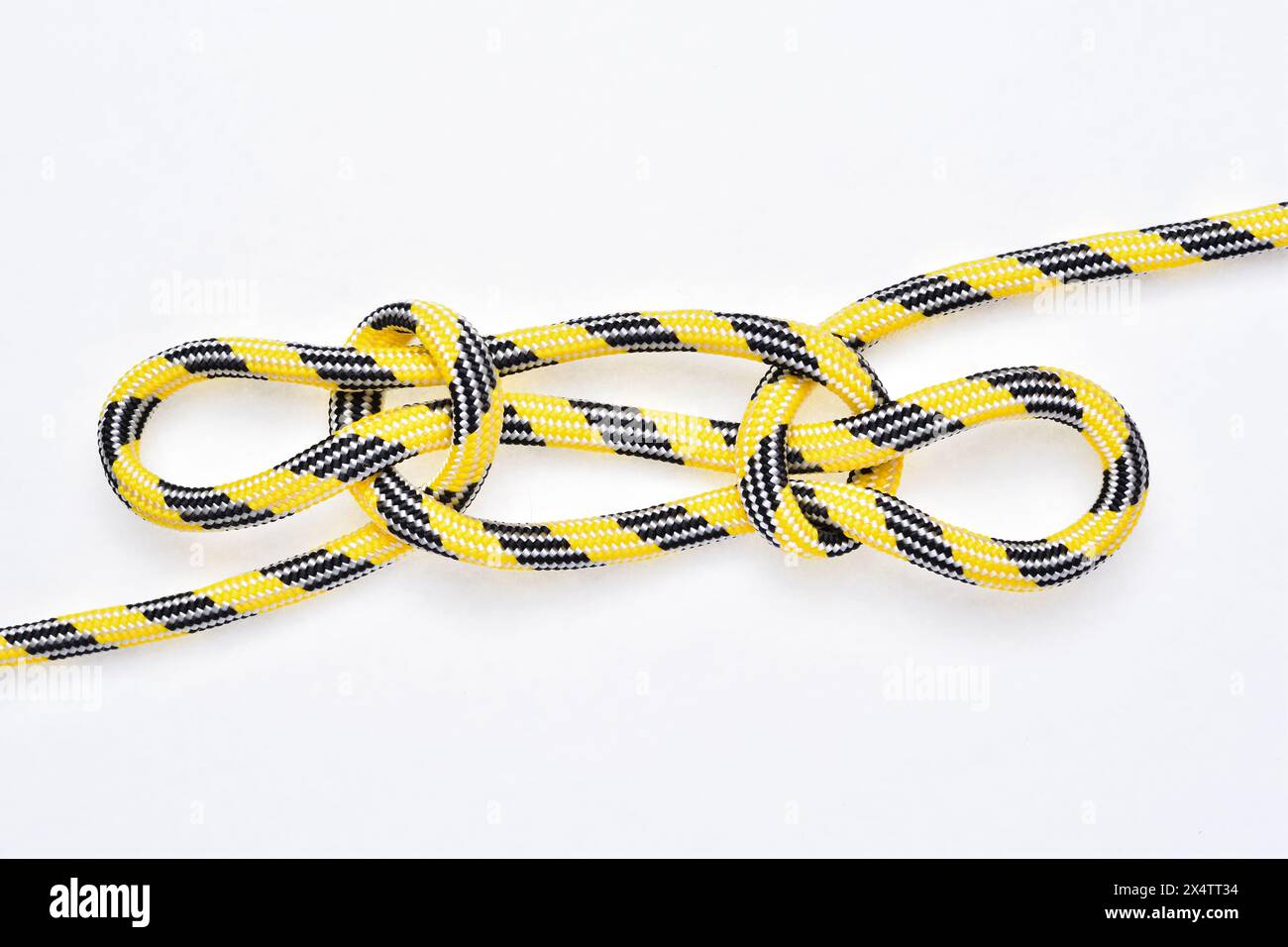 Noeud Sheepshank sur corde en nylon jaune et noir sur fond blanc. Banque D'Images
