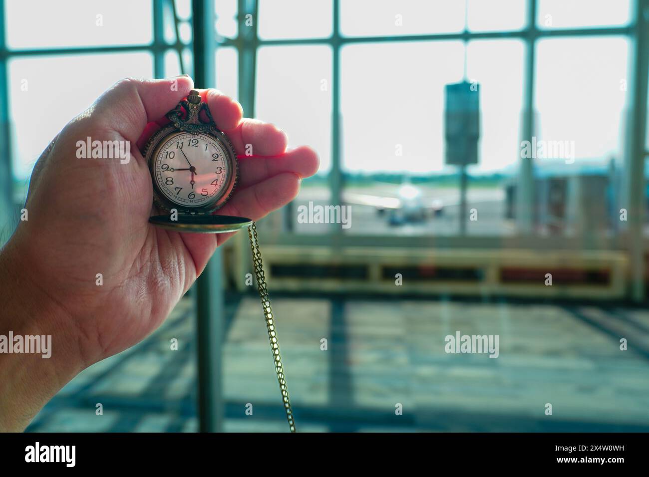 Montre de poche vintage avec fond d'avion flou à l'aéroport Banque D'Images