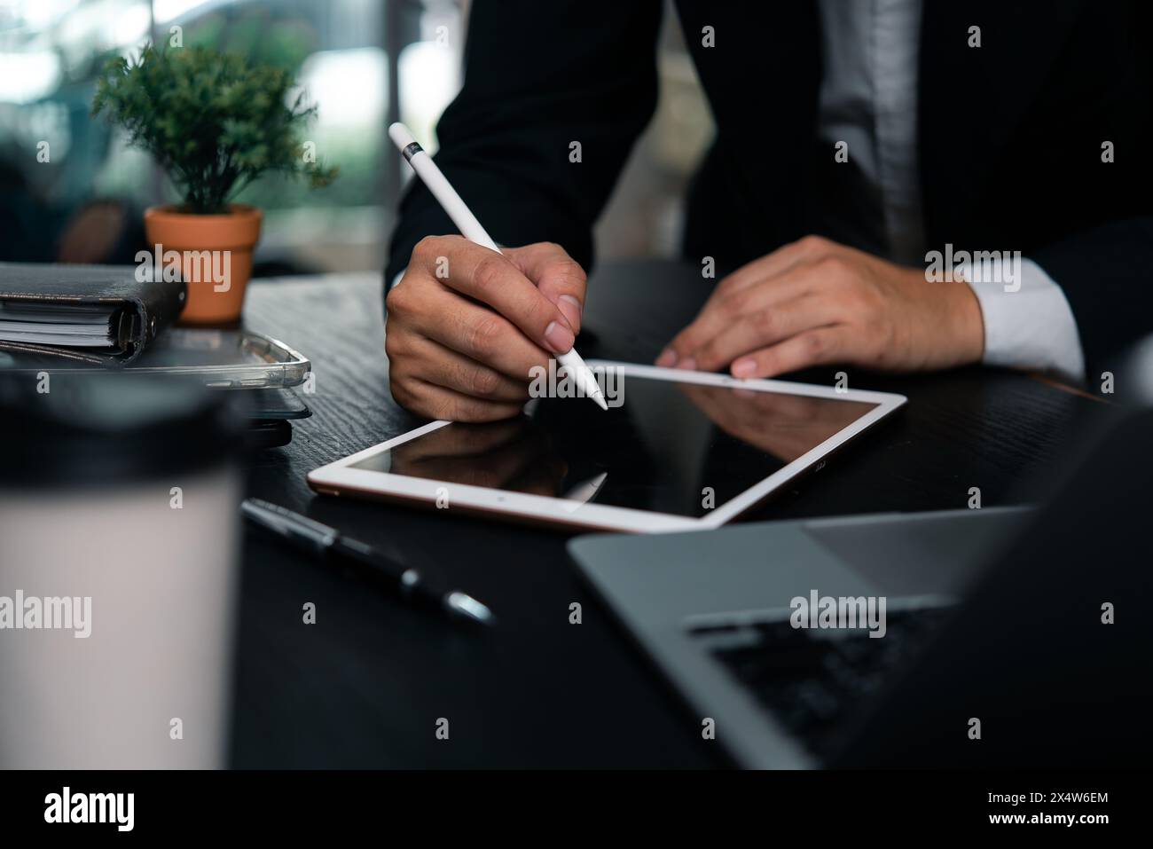 Homme d'affaires travaillant les mains d'une tablette numérique avec un stylet signant des documents, un travail créatif moderne ou la planification de la conception. Banque D'Images