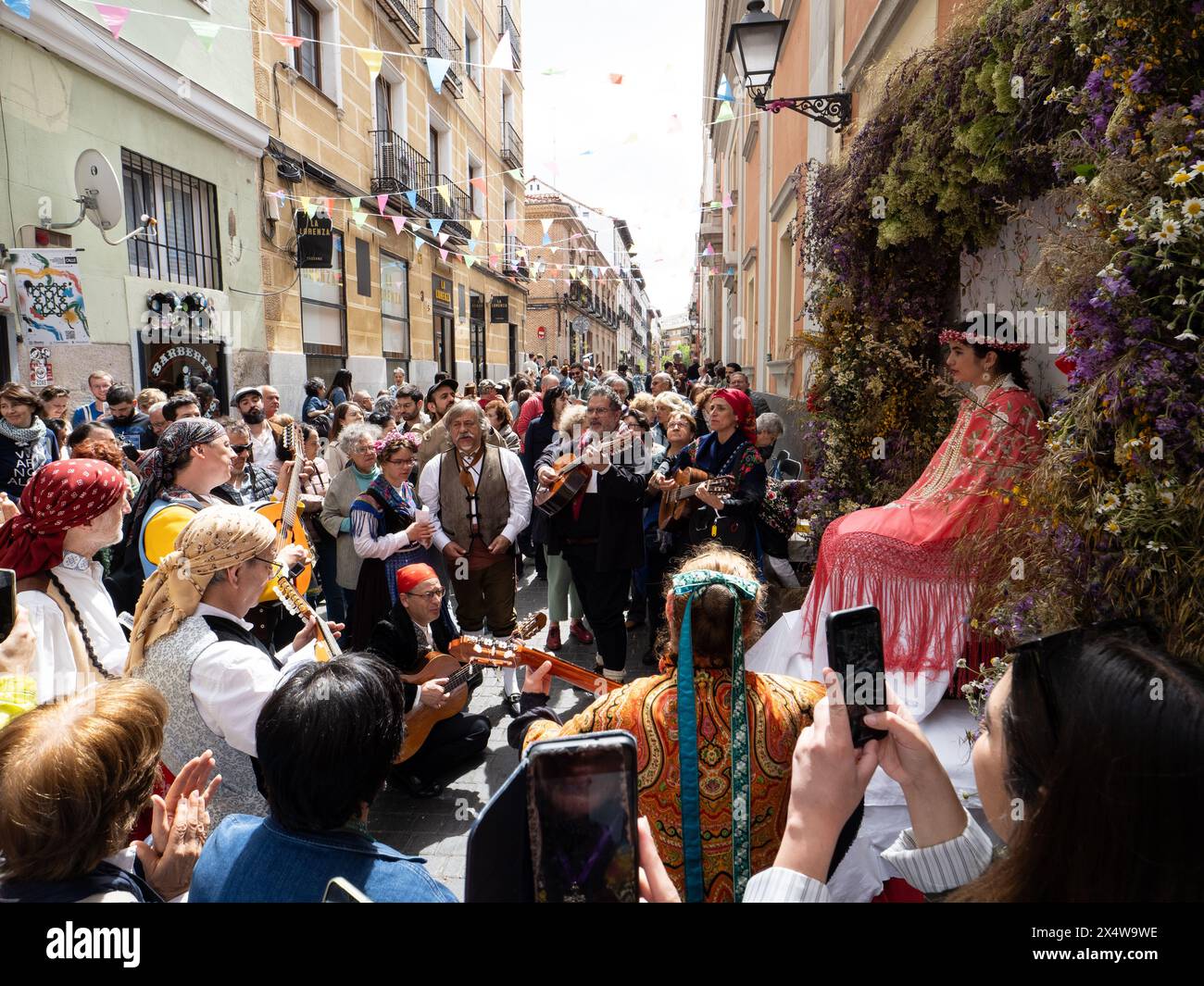 Madrid, Espagne. 5 mai 2024. Un groupe de musique jouant et chantant à Zoe la 'Maya' pendant la célébration du festival 'Las Mayas' à Madrid. « Las Mayas » est une tradition païenne qui célèbre l’arrivée du printemps, adorant les jeunes filles entourées de fleurs et d’offrandes. Cette fête a une origine romaine et a lieu pendant les premiers week-ends de mai dans le quartier Lavapies à Madrid (Espagne). © Valentin Sama-Rojo/Alamy Live News. Banque D'Images