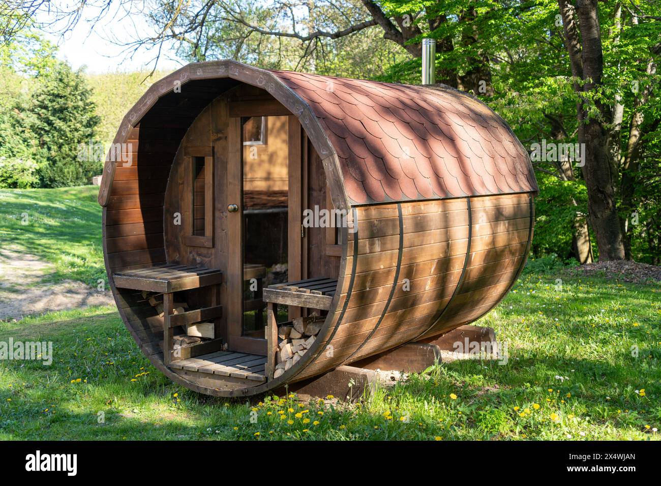 Bâtiment de sauna extérieur rond en bois sur le bord d'une forêt verdoyante Banque D'Images