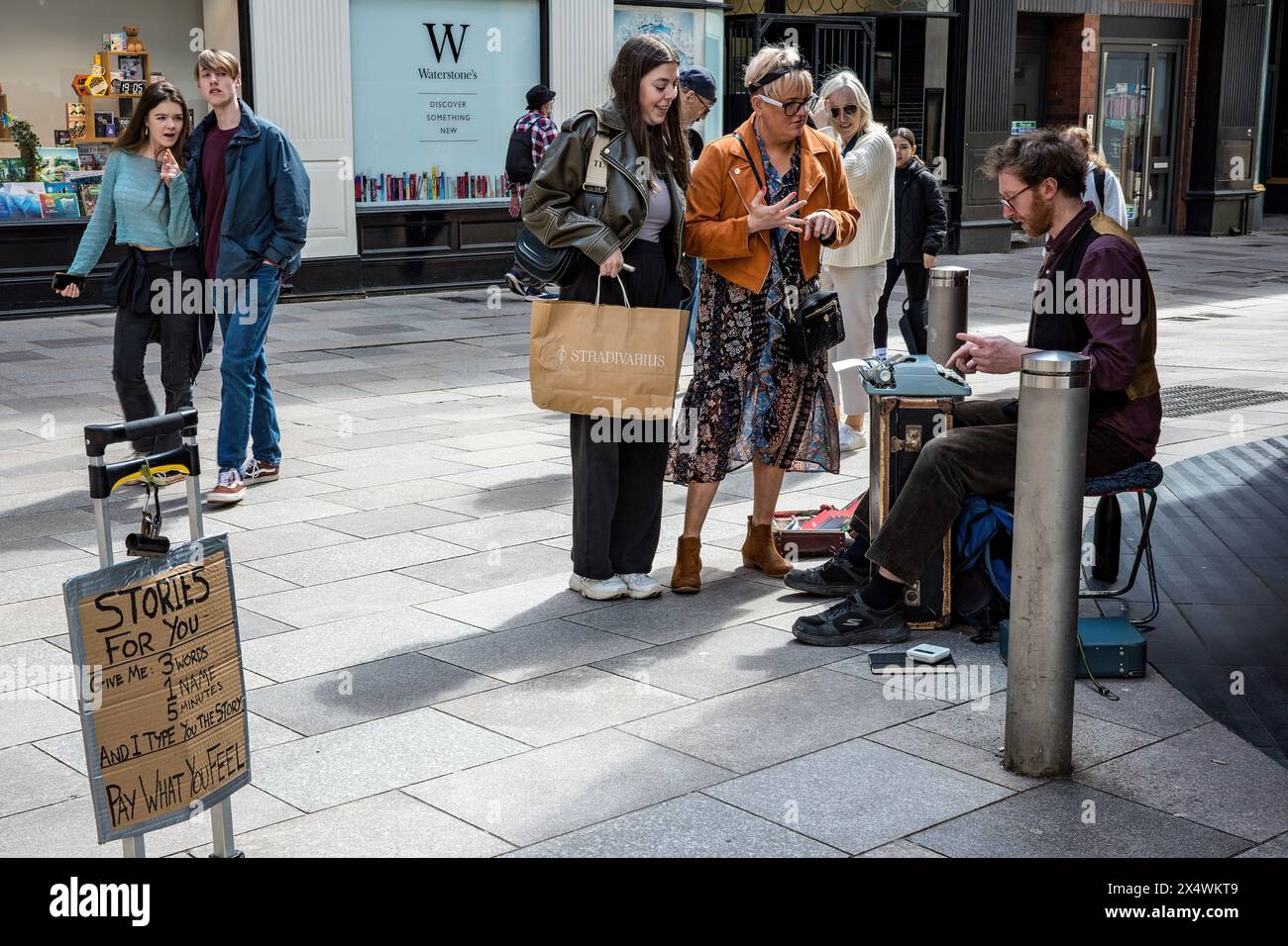 Auteur de rue écrivant des histoires de gens dans le centre-ville. Auteur de busking. L'argent de l'écriture, Street writer. Cardiff, pays de Galles. Banque D'Images