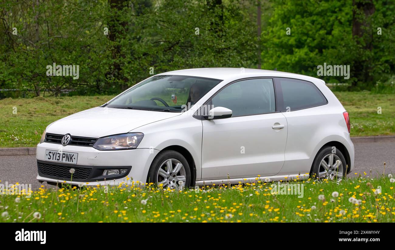 Milton Keynes, Royaume-Uni - 3 mai 2024 : 2013 Volkswagen Polo blanc conduisant sur une route britannique Banque D'Images
