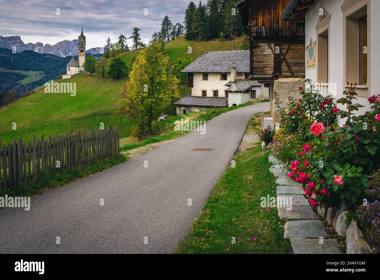Spectaculaire vue sur la rue alpine avec la célèbre chapelle de St Barbara et des maisons traditionnelles sur la pente dans les Dolomites, San Genesio village, Trentin-Sud Banque D'Images