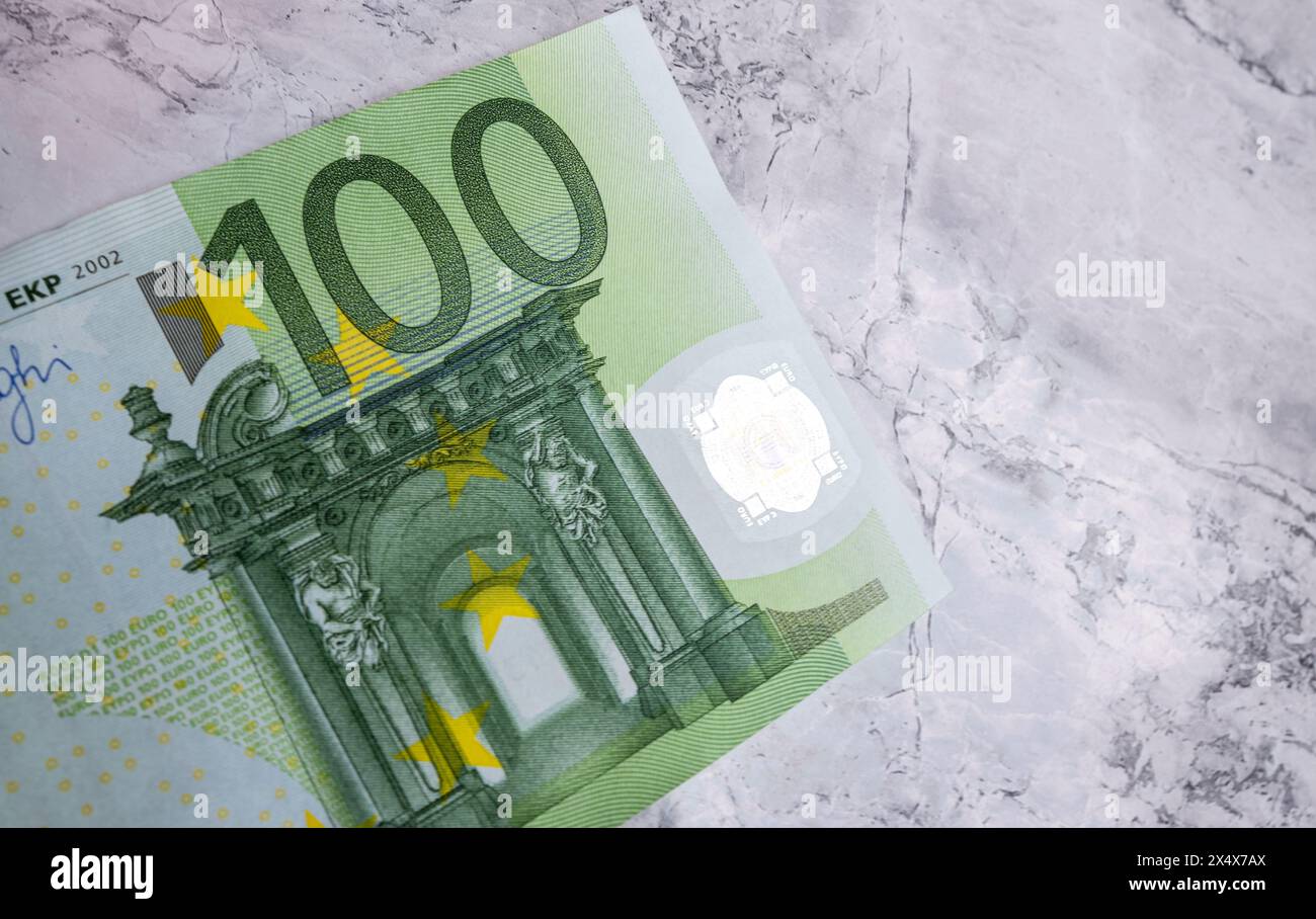 Gros plan de 100 billets en euros isolés sur un fond. Gros plan photo de haute qualité d'un billet de 100 euros couché sur un fond de marbre. Billets en euros, Banque D'Images