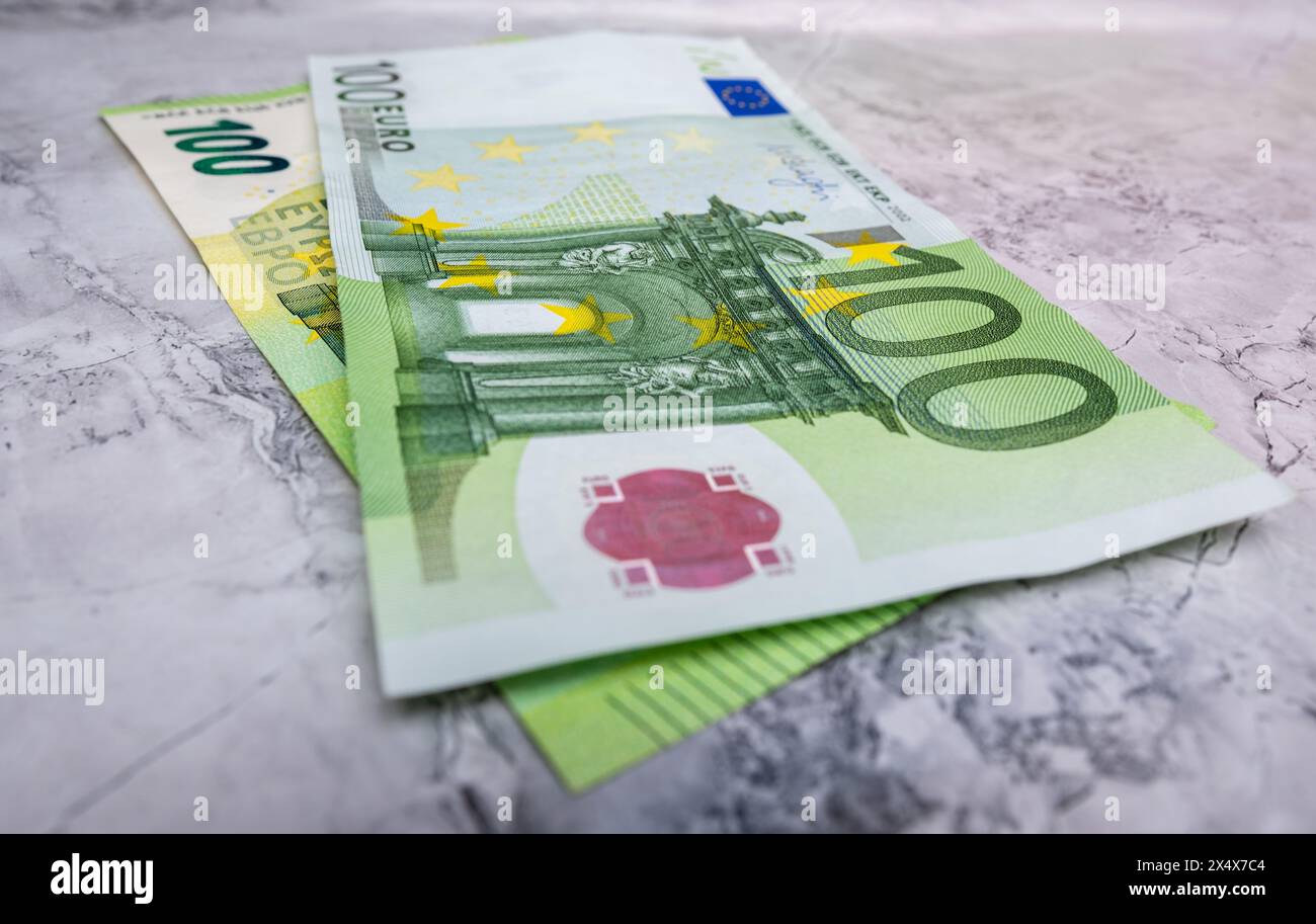 Gros plan de 100 billets en euros isolés sur un fond. Gros plan photo de haute qualité d'un billet de 100 euros couché sur un fond de marbre. Billets en euros, Banque D'Images