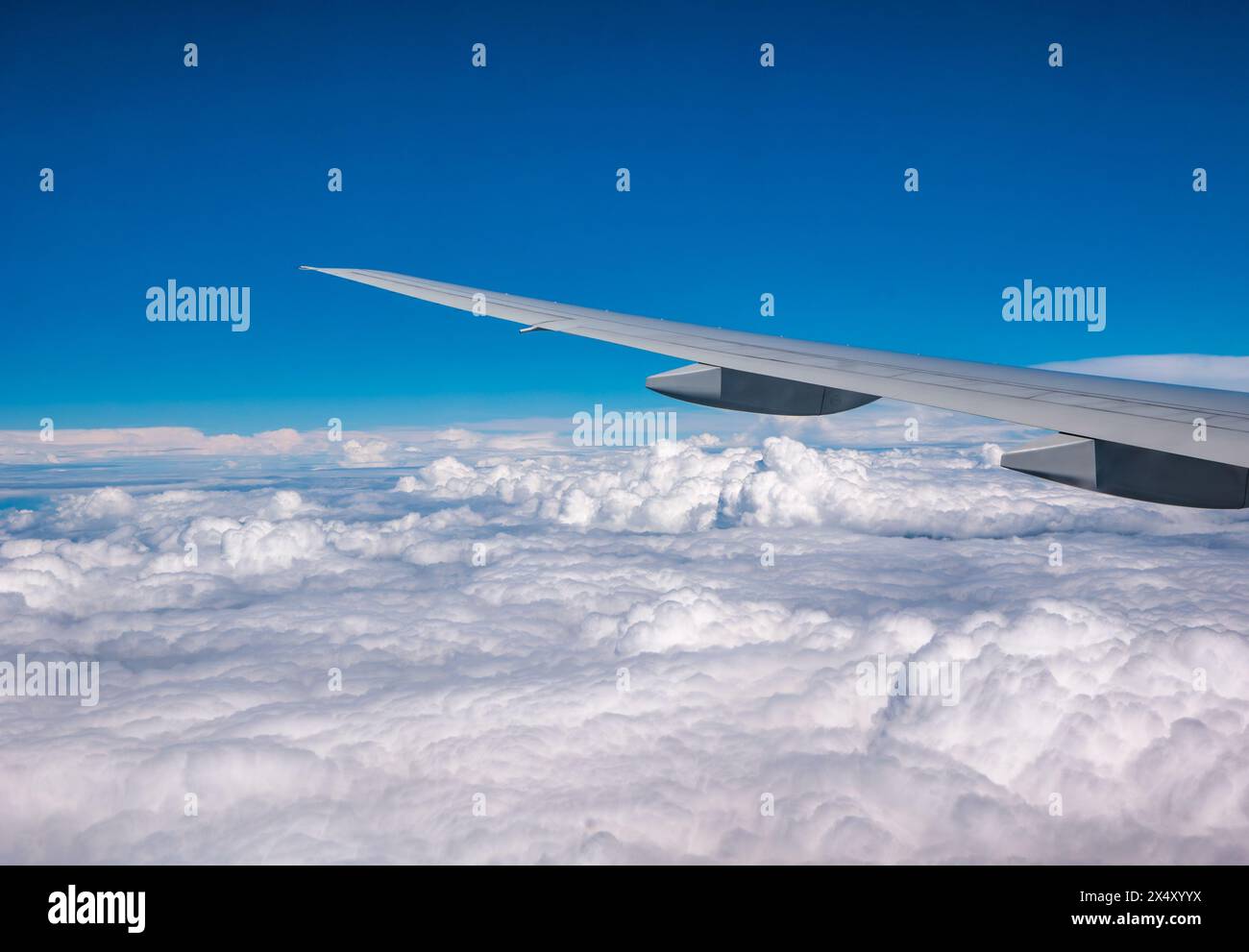 Vue depuis la fenêtre de l'avion de l'aile de l'avion avec le ciel bleu brillant et les nuages blancs gonflés Banque D'Images