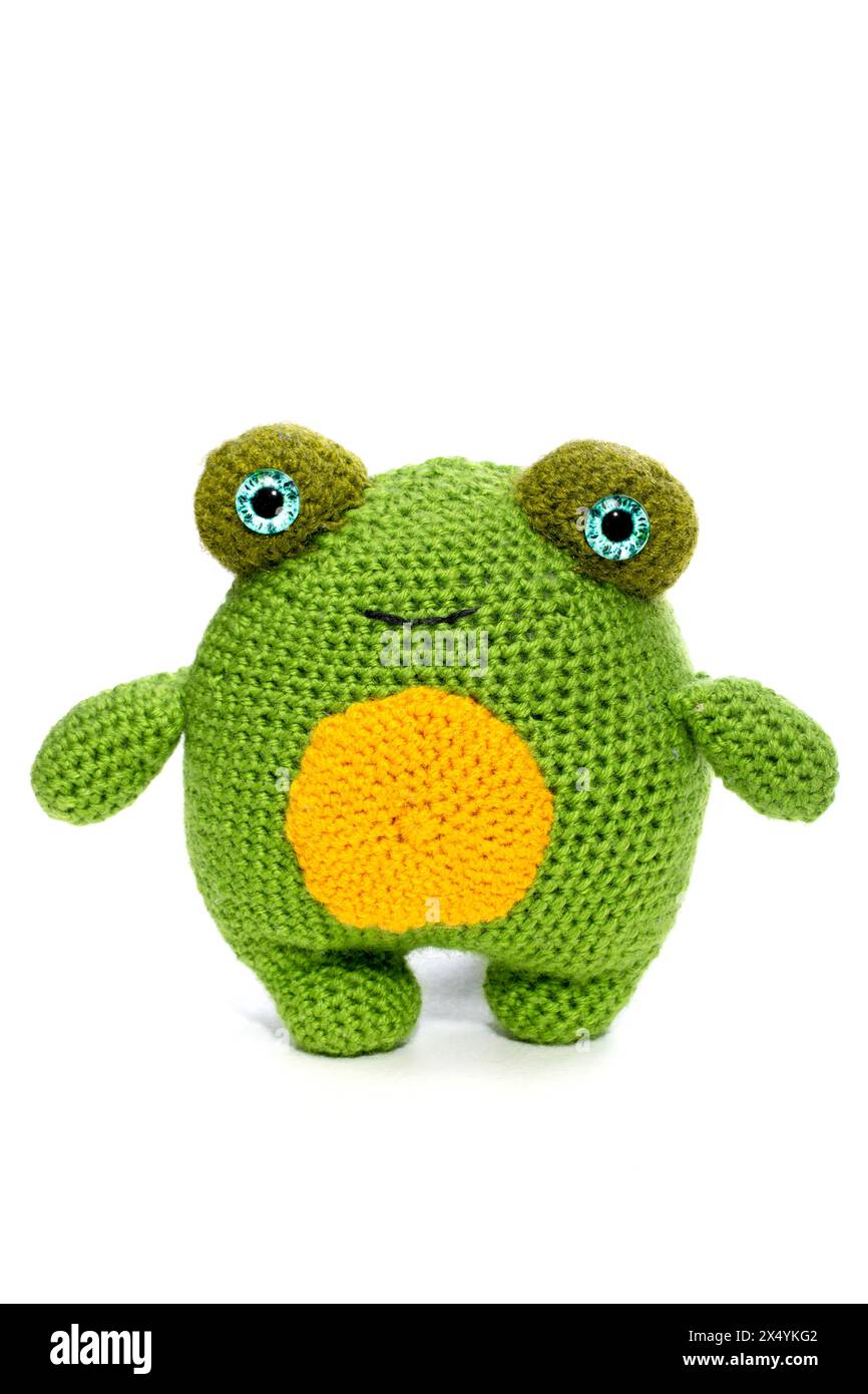 La grenouille est un jouet de laine tricoté doux fait de laine sur un fond blanc Banque D'Images