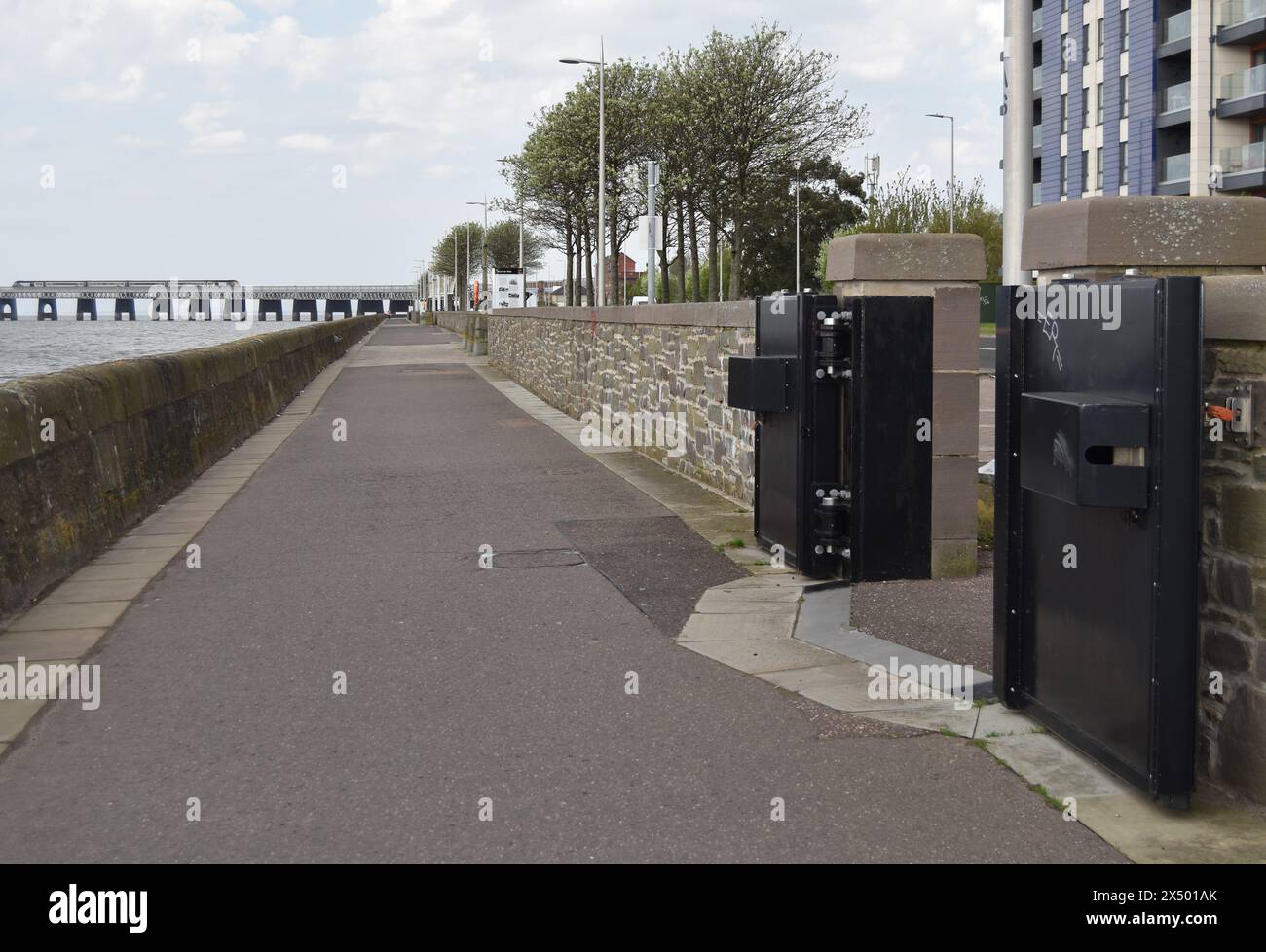 Mur de défense contre les inondations riveraines en pierre et portes d'inondation locales, avec chemin et piste cyclable le long de la rive de la rivière Tay à Dundee, en Écosse. Banque D'Images