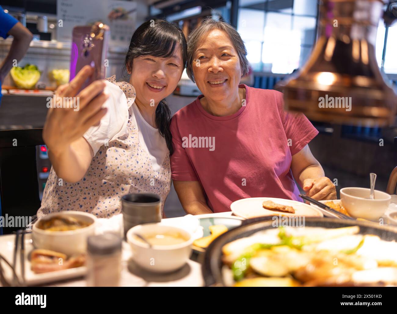 Heureuse mère et fille célébrant la fête des mères et prenant selfie au restaurant Banque D'Images
