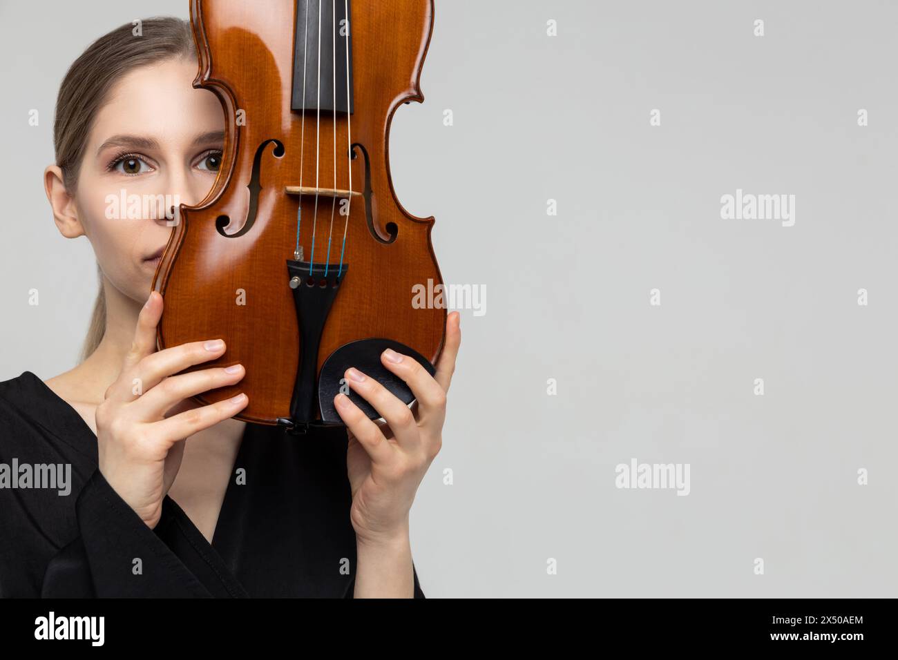 Jeune femme cachant son visage avec du violon Banque D'Images