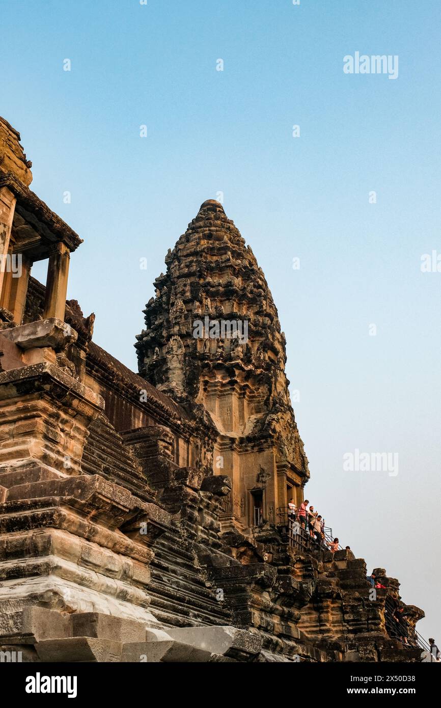 Une vue détaillée révèle la beauté complexe de l'un des temples d'Angkor Wat, debout fièrement sur fond de ciel bleu clair. Banque D'Images