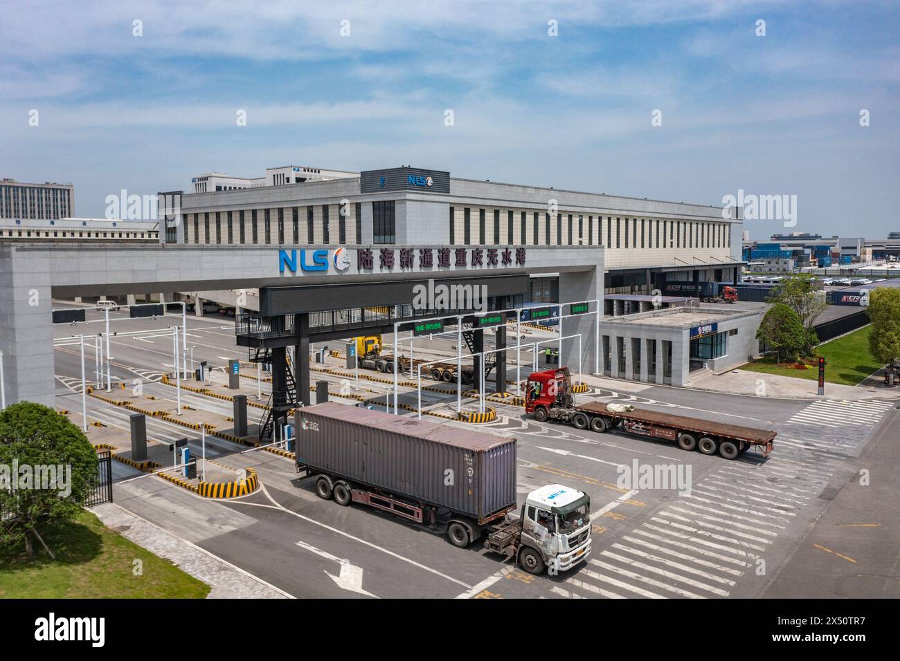(240506) -- CHONGQING, 6 mai 2024 (Xinhua) -- Une photo de drone prise le 5 mai 2024 montre des camions circulant dans le port sec du nouveau corridor international de commerce terre-mer dans la municipalité de Chongqing, dans le sud-ouest de la Chine. Le Chongqing International Logistics Hub Park, qui comprend la gare de Tuanjiecun, le port sec du nouveau corridor de commerce international terre-mer et le port ferroviaire de Chongqing, est devenu un important centre de trains internationaux de marchandises dans la région occidentale du pays. (Xinhua/Huang Wei) Banque D'Images