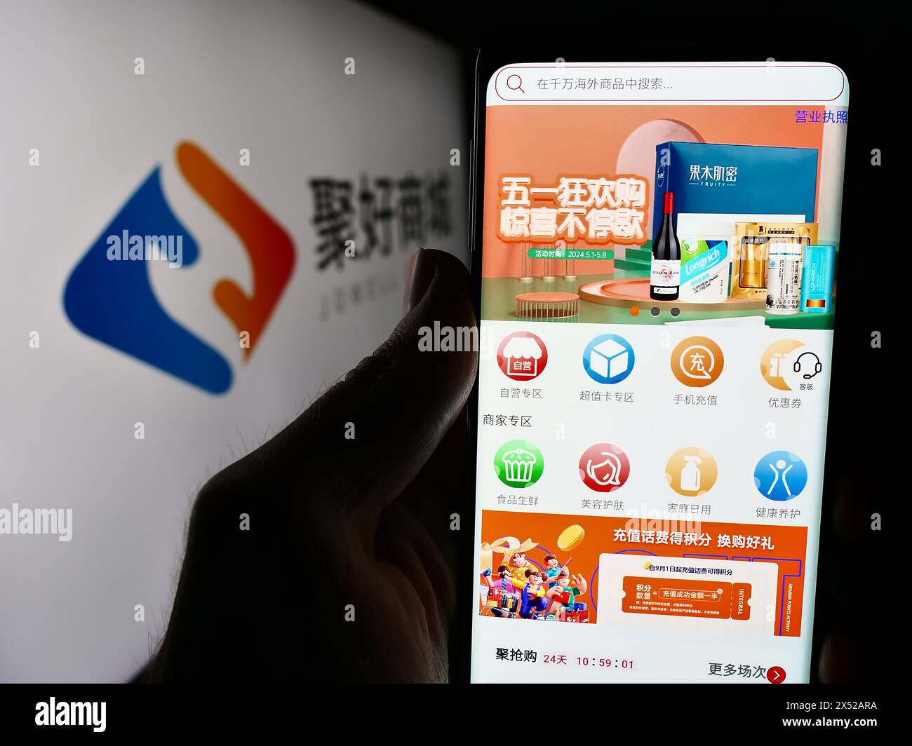Personne tenant le téléphone portable avec la page Web de la société chinoise de commerce électronique Jowell Global Ltd devant le logo. Concentrez-vous sur le centre de l'écran du téléphone. Banque D'Images