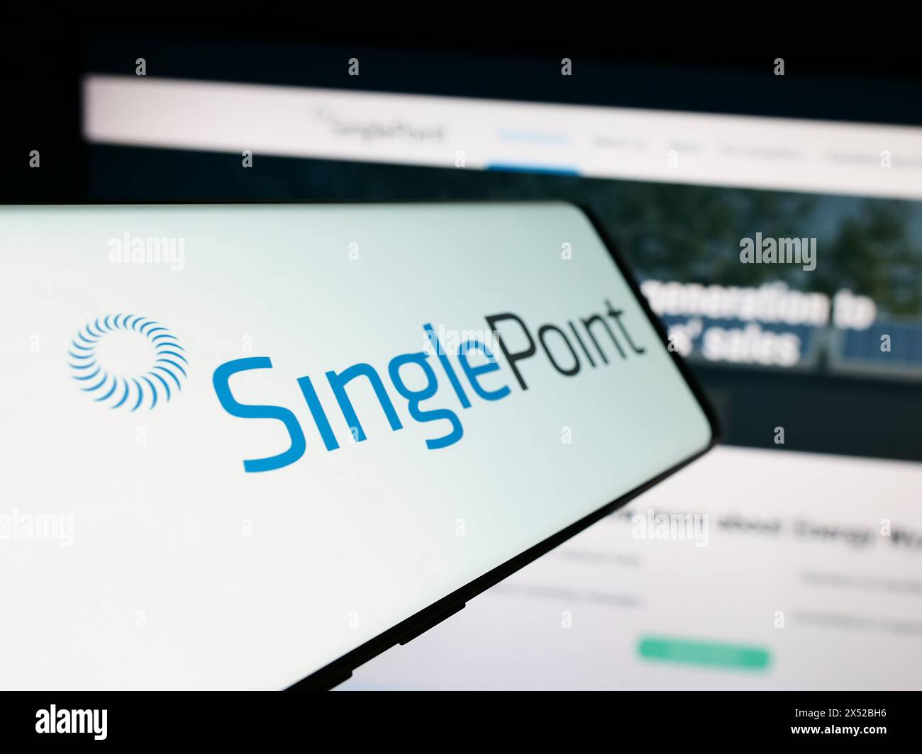 Téléphone portable avec le logo de la société américaine d'énergie renouvelable Singlepoint Inc devant le site Web de l'entreprise. Focus à gauche de l'écran du téléphone. Banque D'Images
