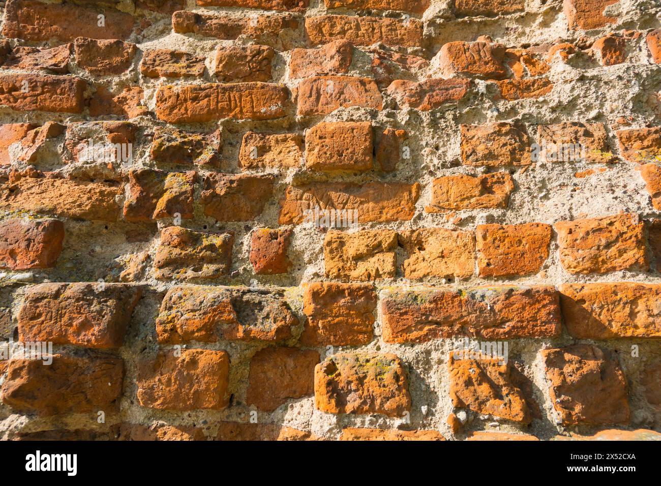 L'image capture les effets du temps sur une structure,. un vieux mur de briques altérées. Chaque brique raconte une histoire d'âge et d'exposition aux éléments, cr Banque D'Images