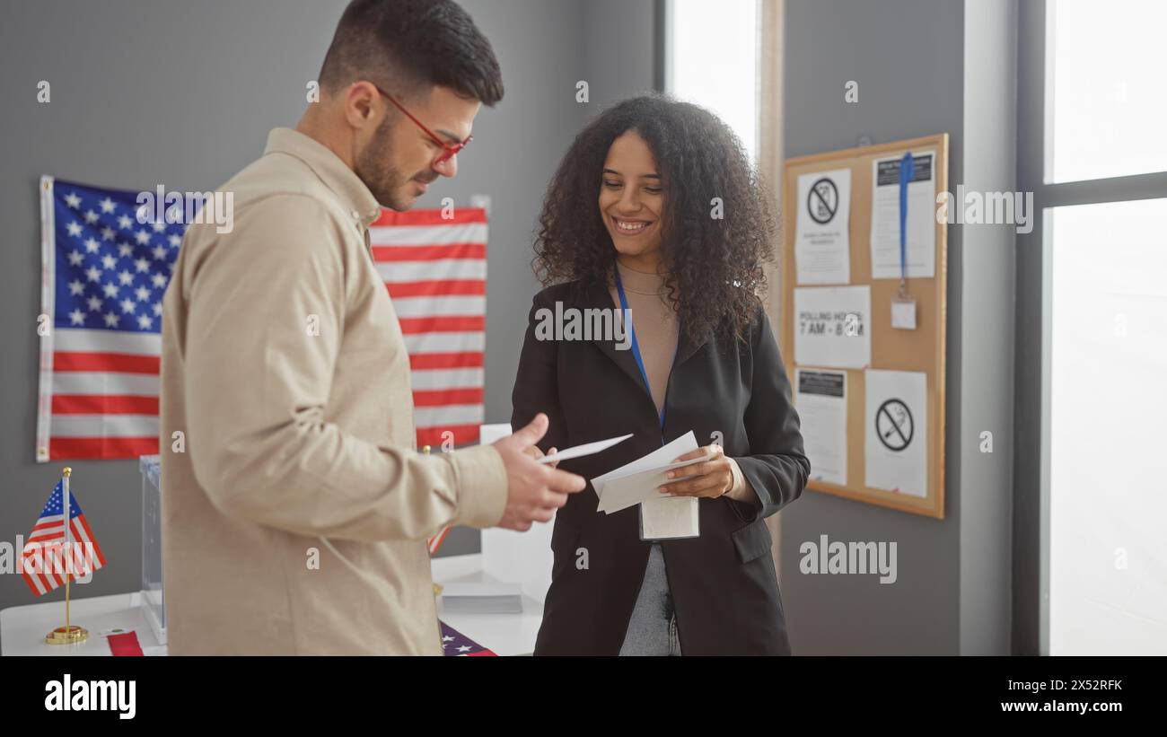 Un homme et une femme échangent des documents dans une salle de collège électoral américain avec des drapeaux américains. Banque D'Images