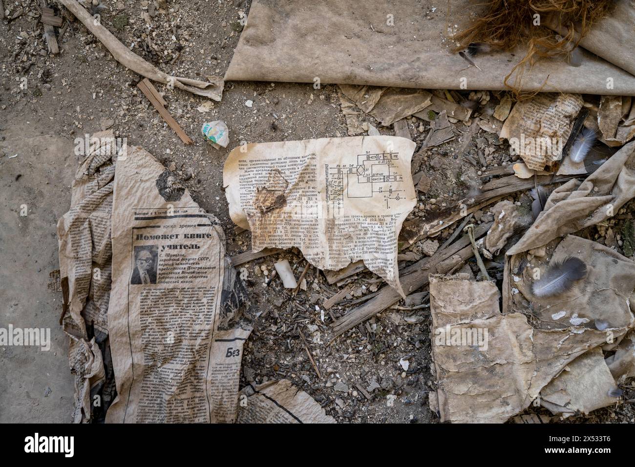 Restes d'un vieux journal kirghize de 1924 et un manuel d'instructions avec schéma de circuit en caractères cyrilliques dans un bâtiment abandonné, ville fantôme Banque D'Images