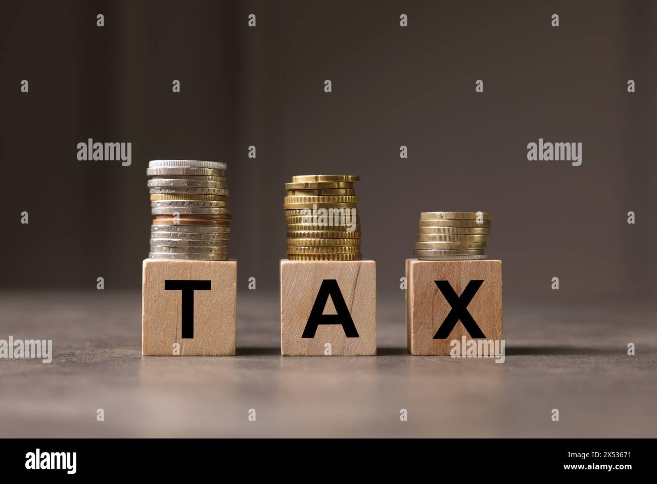 Word Tax fait de lettres et de pièces de monnaie en bois sur une table grise Banque D'Images