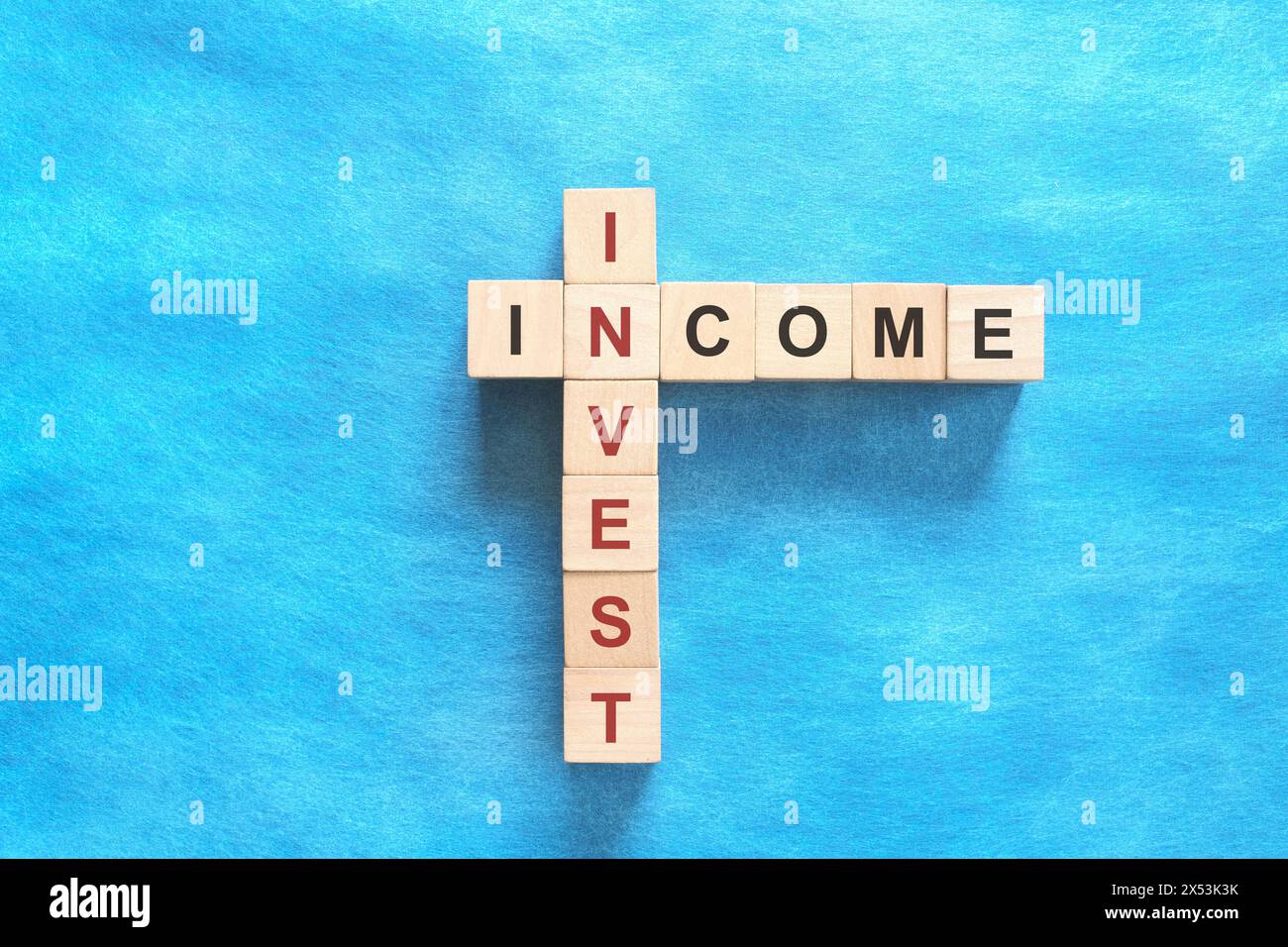 Investir le concept de financement du revenu. Mots croisés puzzle plat sur fond bleu. Banque D'Images