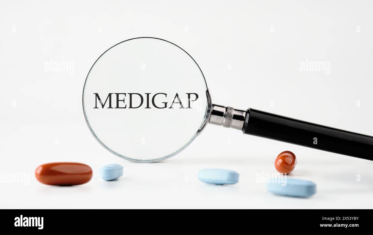 Concept médical. MEDIGAP sur fond blanc à travers une loupe Banque D'Images