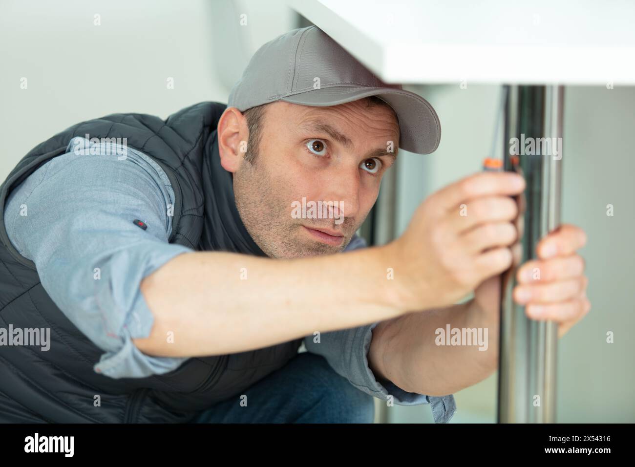 homme fixant le pied de la table Banque D'Images