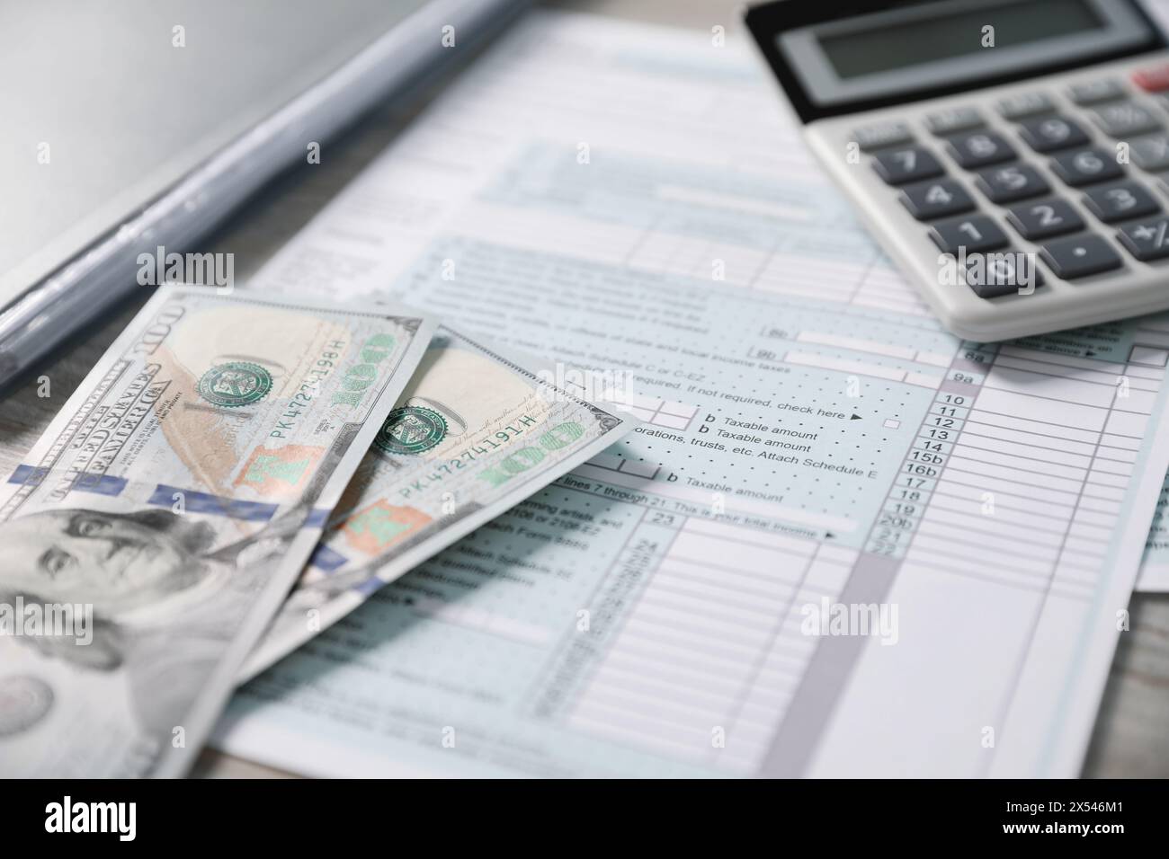 Paie. Formulaires de déclaration d'impôt, calculatrice et billets de banque en dollars sur table, focus sélectif Banque D'Images