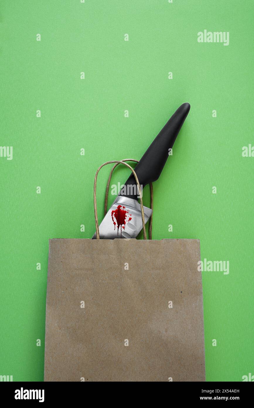Couteau de cuisine sanglant dans un sac en papier brun. Banque D'Images