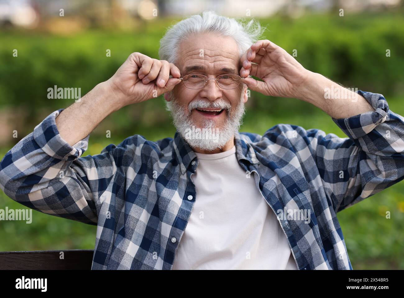 Portrait de grand-père heureux avec des lunettes sur le banc dans le parc Banque D'Images
