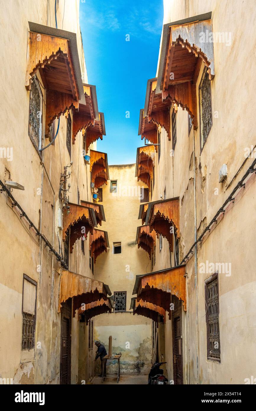 Ruelle étroite avec des auvents en bois ornées dans la médina de Fès. Banque D'Images