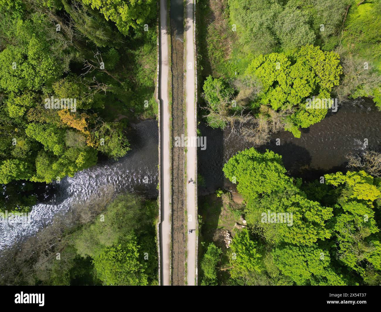 Vue aérienne du canal de Cromford alors qu'il passe au-dessus de la rivière Derwent dans le Derbyshire avec des marcheurs sur le chemin du canal - photo mai 2024 Banque D'Images