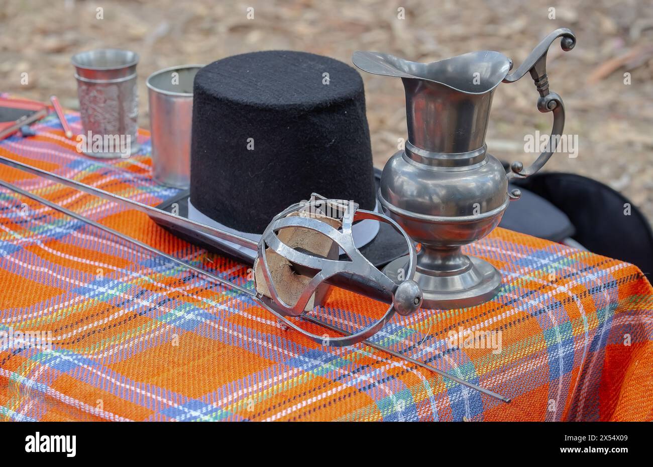 Accessoires pour une foire médiévale, épée, tasse de fer et chapeau noir. Photo de haute qualité Banque D'Images