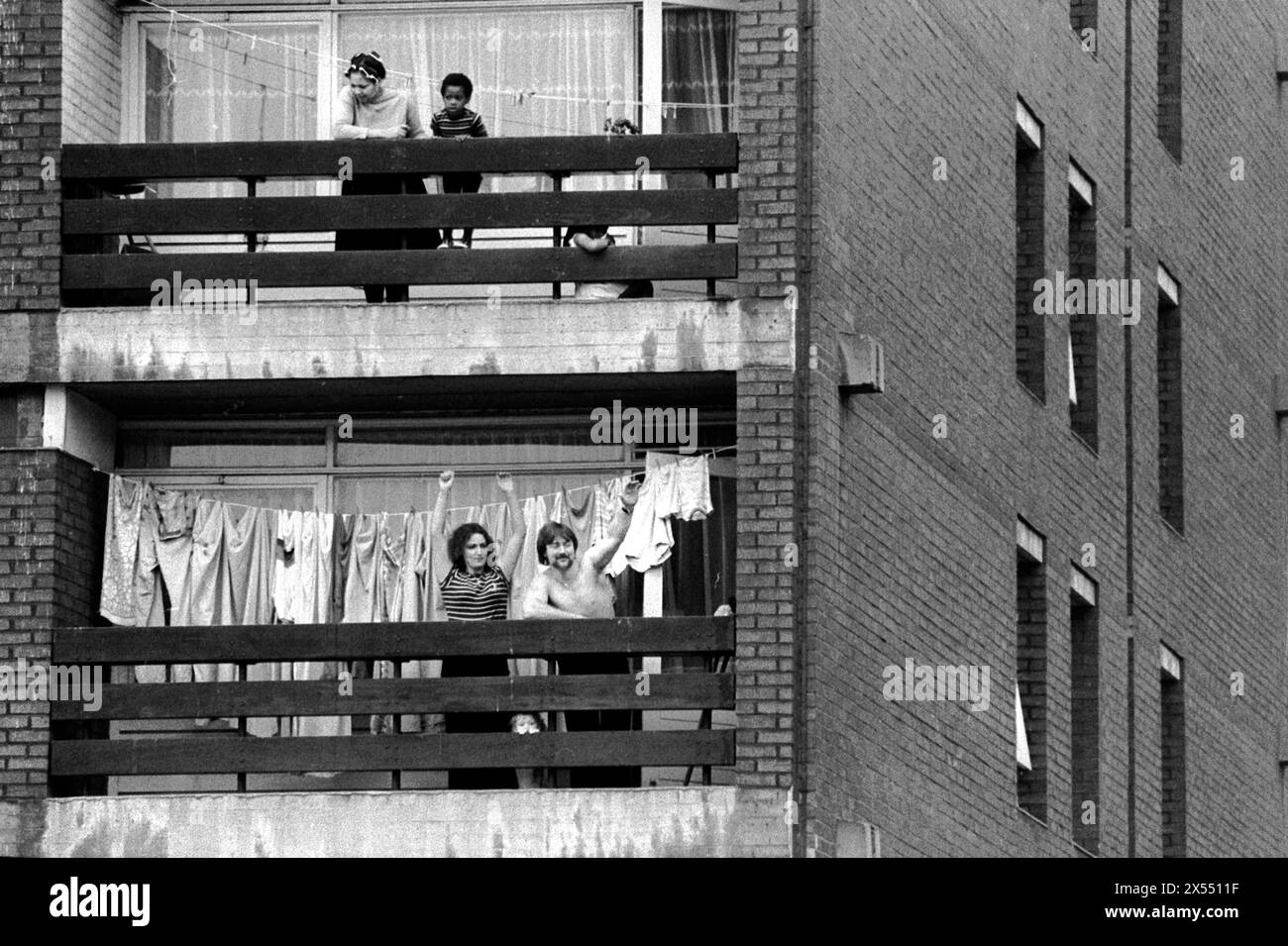 New Cross, Londres, Angleterre 13 août 1977. Un Front national soutenant la famille acclament et manifestent leur soutien depuis le balcon de leur appartement de la tour, tandis que leur voisin à l'étage et leurs deux enfants ne sont pas si extatiques. UK 1970S UK HOMER SYKES Banque D'Images